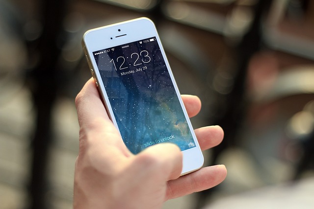 Hånd som holder i en mobiltelefon